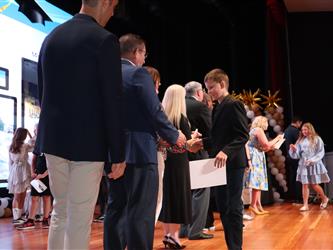 student shaking admin hands on stage