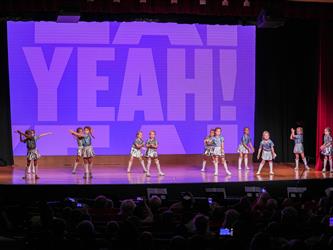 students performing dance on stage