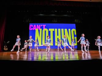 students performing dance on stage