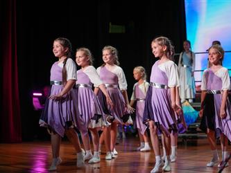 students performing dance on stage