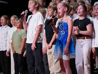 students lined up to sing on stage