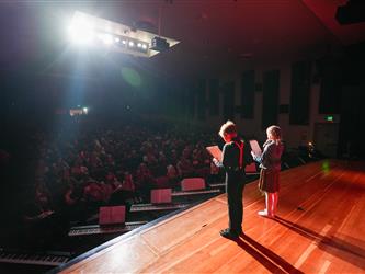 student hosts addressing the crowd