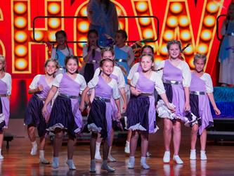 students performing dance on stage