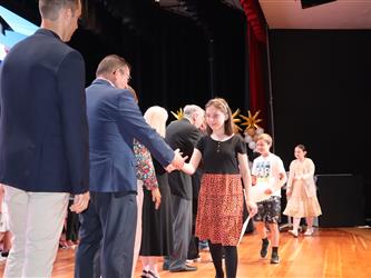 student shaking admin hands on stage